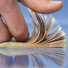image of a hand flipping through dollar bills
